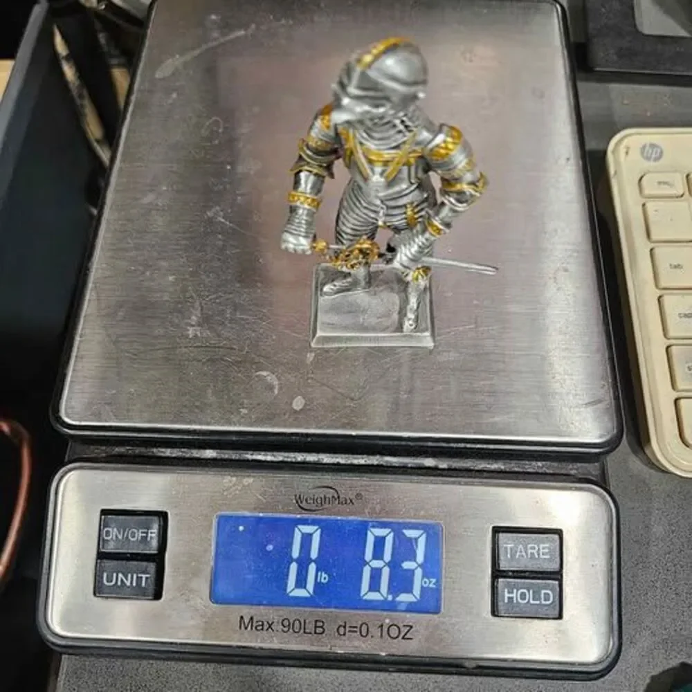 Small metal knight figurine with armor and sword